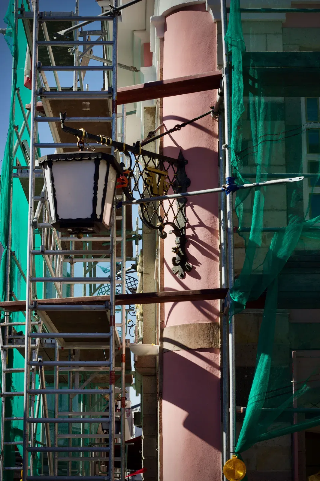 Edificio de una comunidad de propietarios en rehabilitación de fachada con andamios, obra subvencionada que no computa como ingreso para el Ingreso Mínimo Vital según la STS 56/2026